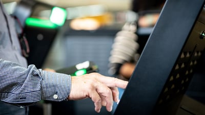 Person tapping on a kiosk screen