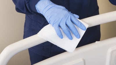 Gloved hand cleaning bed guard rail
