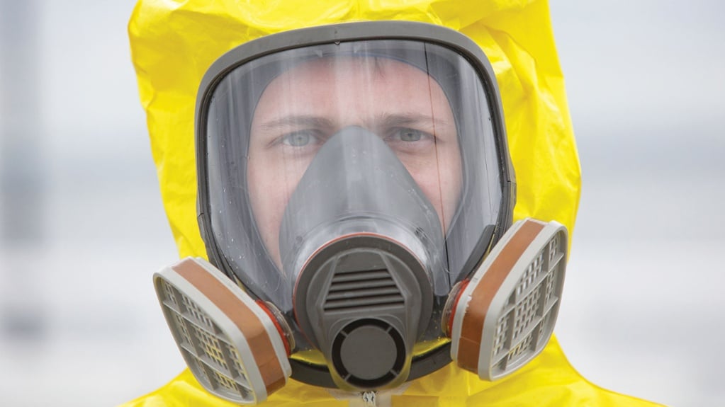 man in yellow hazmat suit with gas mask on